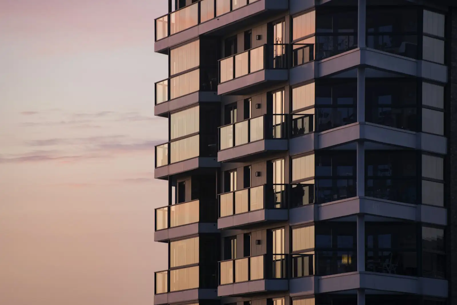 Mid-rise apartment building with balconies at dusk
